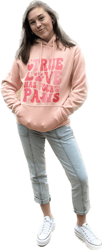 a woman wearing a pink hoodie and jeans