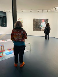 a woman looking at paintings in an art gallery
