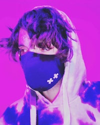 a man in a tie dye hoodie wearing a face mask