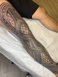 a man with a tribal tattoo on his leg