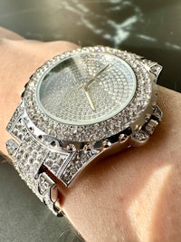 a woman's wrist with a diamond watch on it