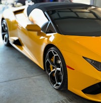 a yellow sports car is parked in a garage