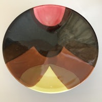 a plate with a brown, yellow, and orange design