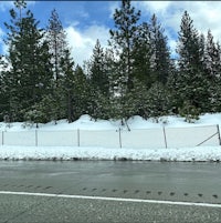 a snow covered road with trees in the background