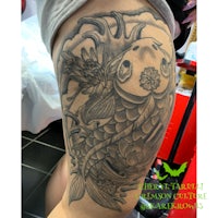 a koi fish tattoo on a woman's thigh