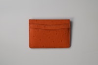 an orange card holder on a white surface