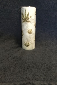a white vase with marijuana leaves on it