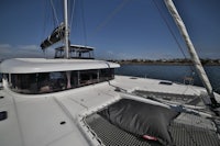 a white catamaran is docked in a body of water