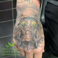 a tattoo of a gas mask on a hand