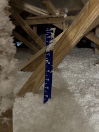 a man is measuring the amount of insulation in an attic