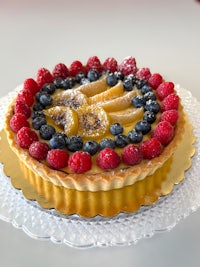 a fruit tart with blueberries and raspberries on a plate