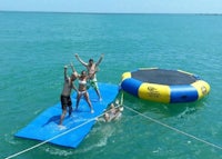 a group of people playing on an inflatable raft in the water