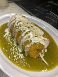 a plate of green enchiladas on a white plate
