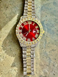 a red and gold watch with diamonds on it