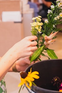 a woman is arranging flowers in a bowl