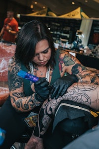 a woman getting tattooed at a convention