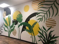a hallway with a mural of tropical plants and leaves
