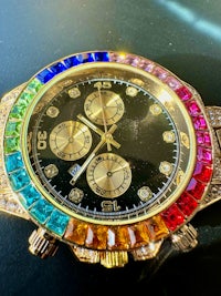 a watch with multi colored stones on it