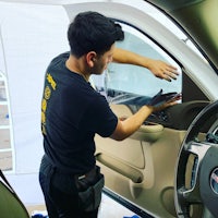 a man is working on the door of a car