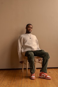 a man sitting on a chair in front of a wall