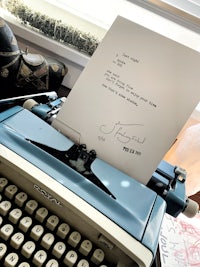 a blue typewriter with a letter sitting on top of it
