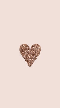 a heart made of brown glitter on a beige background