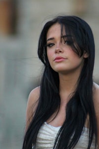 a woman with long black hair is posing for a picture