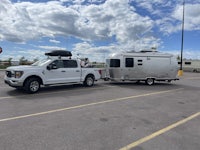 a truck towing an airstream trailer in a parking lot