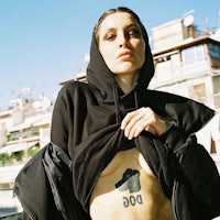 a woman in a black hoodie with a dog tattoo on her chest