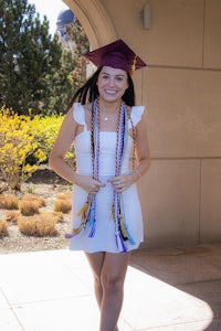 a young woman wearing a graduation gown and tassel