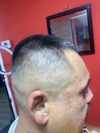 a man with a shaved head in a barber shop