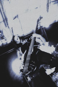 a person playing a bass guitar in a dark room