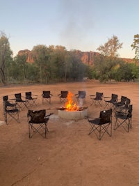 a group of chairs around a fire pit in the desert