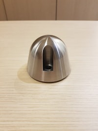 a stainless steel knob on a wooden table