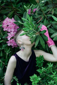 a woman wearing a pink glove is surrounded by flowers