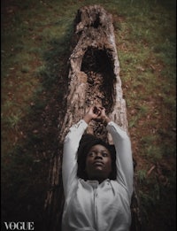 a woman laying on a log in the woods