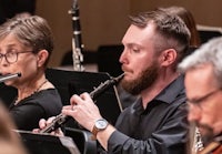 a man playing a clarinet in an orchestra