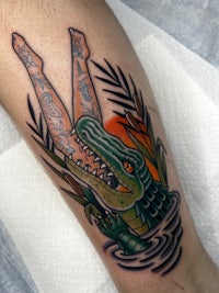 a tattoo of a crocodile in the water