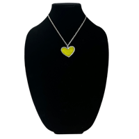 a yellow heart pendant on a black mannequin