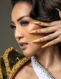 a woman with gold nails posing for a photo