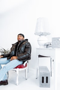 a man sitting on a chair in a white room