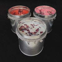 three candle tins with flowers in them