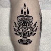 a black and white tattoo of a goblet with a rose on it