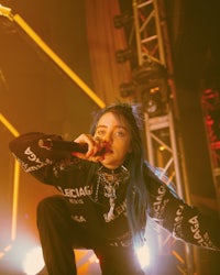 a woman with blue hair singing into a microphone