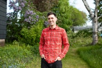 a man in a red plaid shirt standing in a field