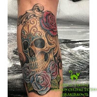 a skull tattoo with roses and flowers