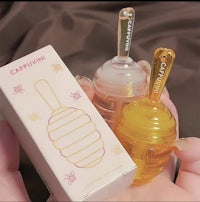 a person holding a bottle of beeswax and a box of honey