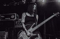 a black and white photo of a woman playing a bass