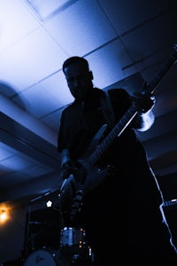 a man playing a bass in a dark room