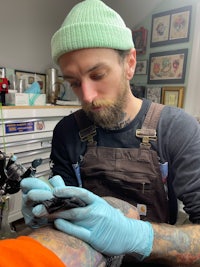 a man is getting a tattoo in a tattoo shop